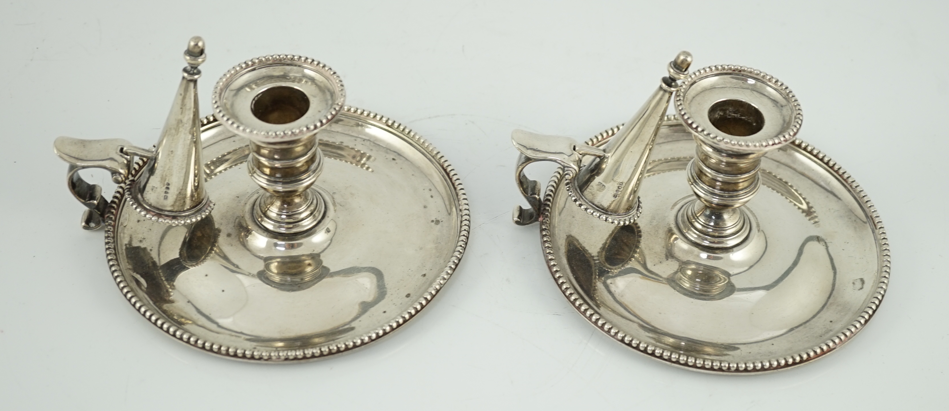 A pair of Victorian silver chambersticks and extinguishers, by Charles Thomas Fox and George Fox